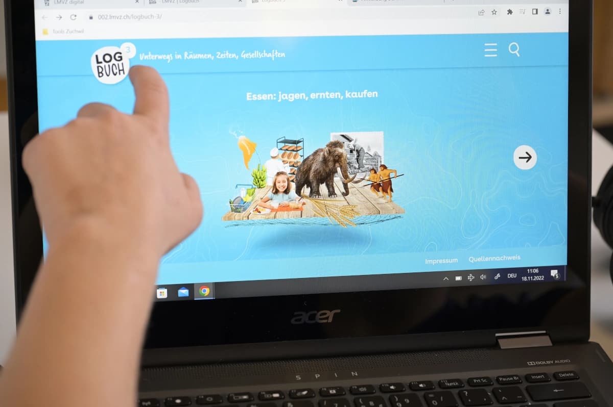 Ein Bildschirm eines Laptops zeigt eine Aufgabe aus Logbuch. Zu sehen ist eine Collage mit Tieren, Nahrungsmitteln, Menschen.
