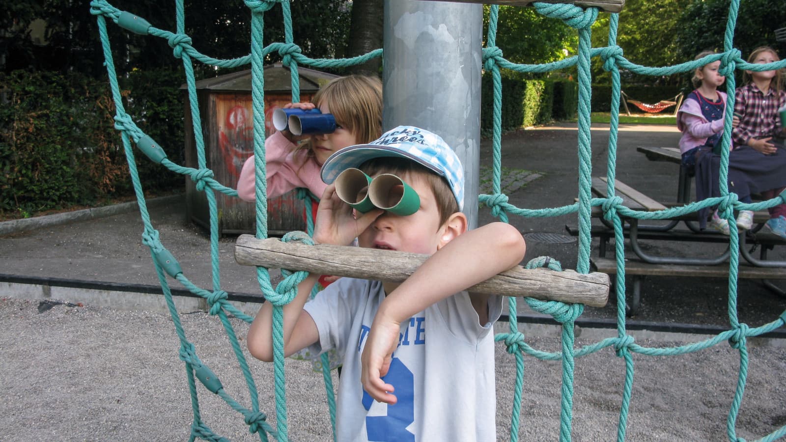 Ein Kind beobachtet mit einem Fernglas das Wetter